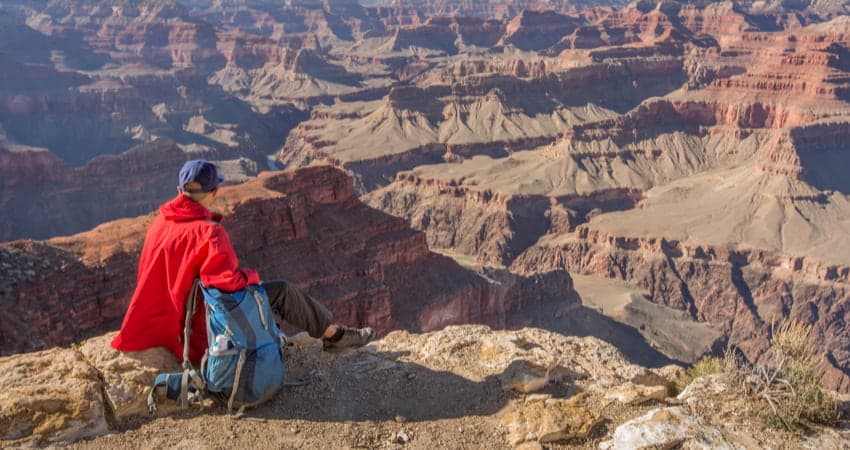 a hiker looks out across the Grand Canyon in Arizona