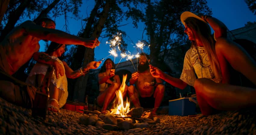 a group of campers come together over a campfire