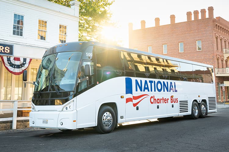 A charter bus with National Charter Bus branding, waiting to load up passengers