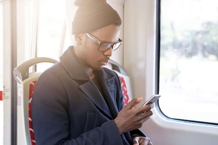 Young man looking at cell phone on bus