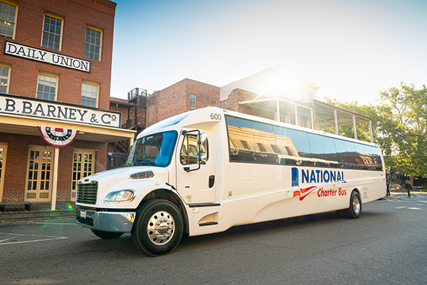 a bus with the national charter bus logo parked in a parking lot