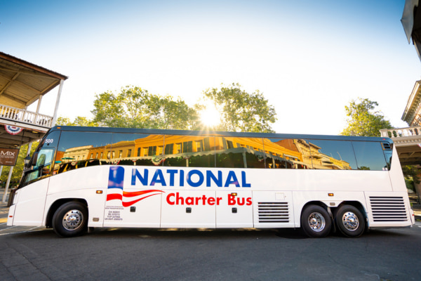 a large charter bus with the 'national charter bus' logo drives by