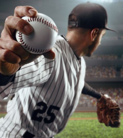 A baseball pitcher winding up for a pitch