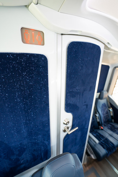 a door leading to a restroom on a charter bus