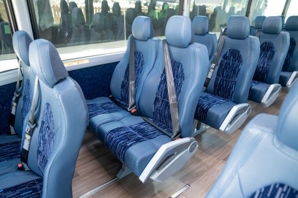 blue charter bus seats with buckled seatbelts