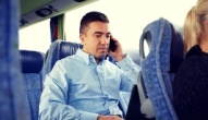 a man takes a call while riding a shuttle bus