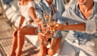 Travelers toast glasses of alcohol on a boat