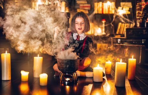 little girl in witch Cosplay brews potion, Halloween costume